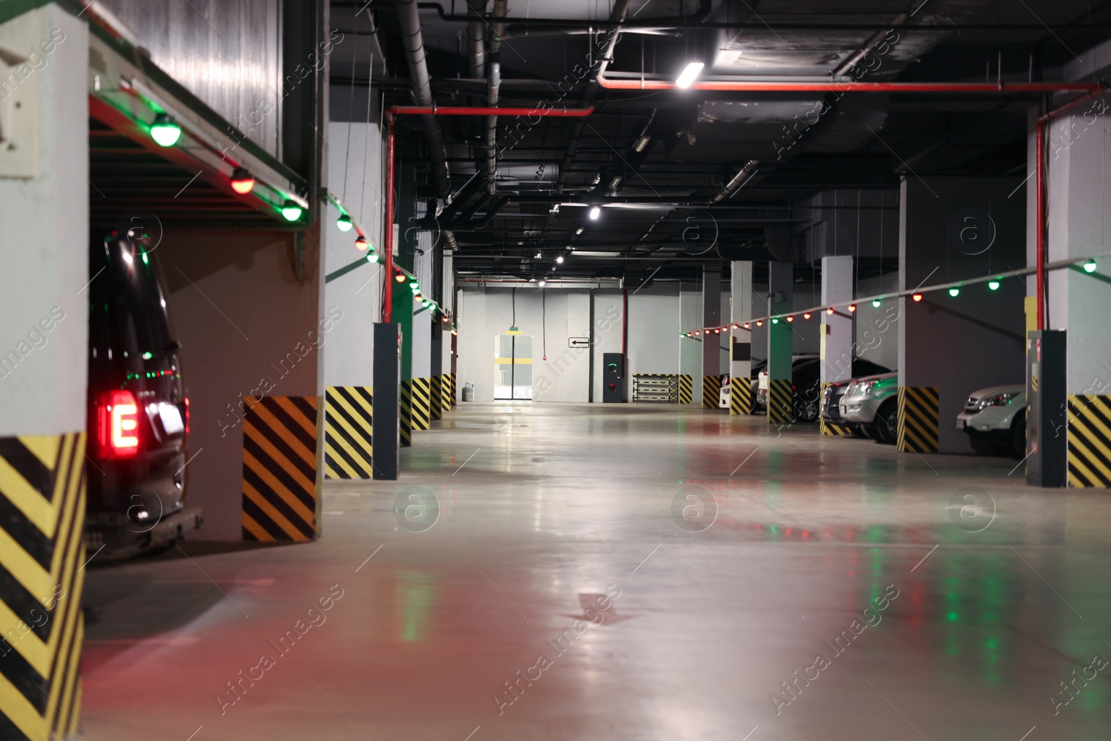 Photo of Modern parking garage with cars at night