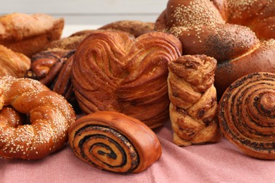 Different tasty freshly baked pastries on pink tablecloth