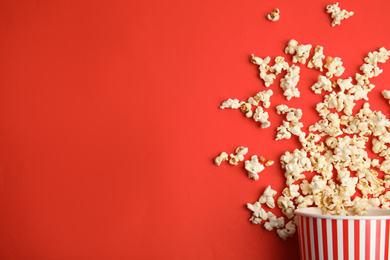 Photo of Tasty pop corn on red background, flat lay. Space for text