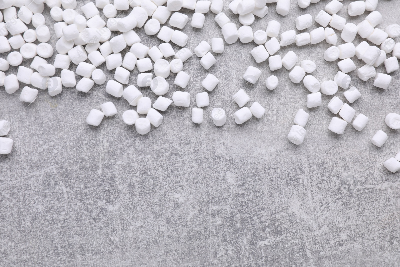 Photo of Delicious marshmallows on light gray background, flat lay. Space for text