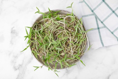 Photo of Mung bean sprouts in bowl on white marble table, top view