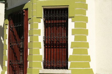 Photo of Beautiful door and window with grills on building, view from outdoors