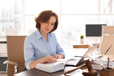 Female lawyer working at table in office