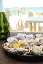 Photo of Fresh oysters with cut juicy lemon served on table