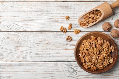 Photo of Flat lay composition with walnuts and space for text on wooden background