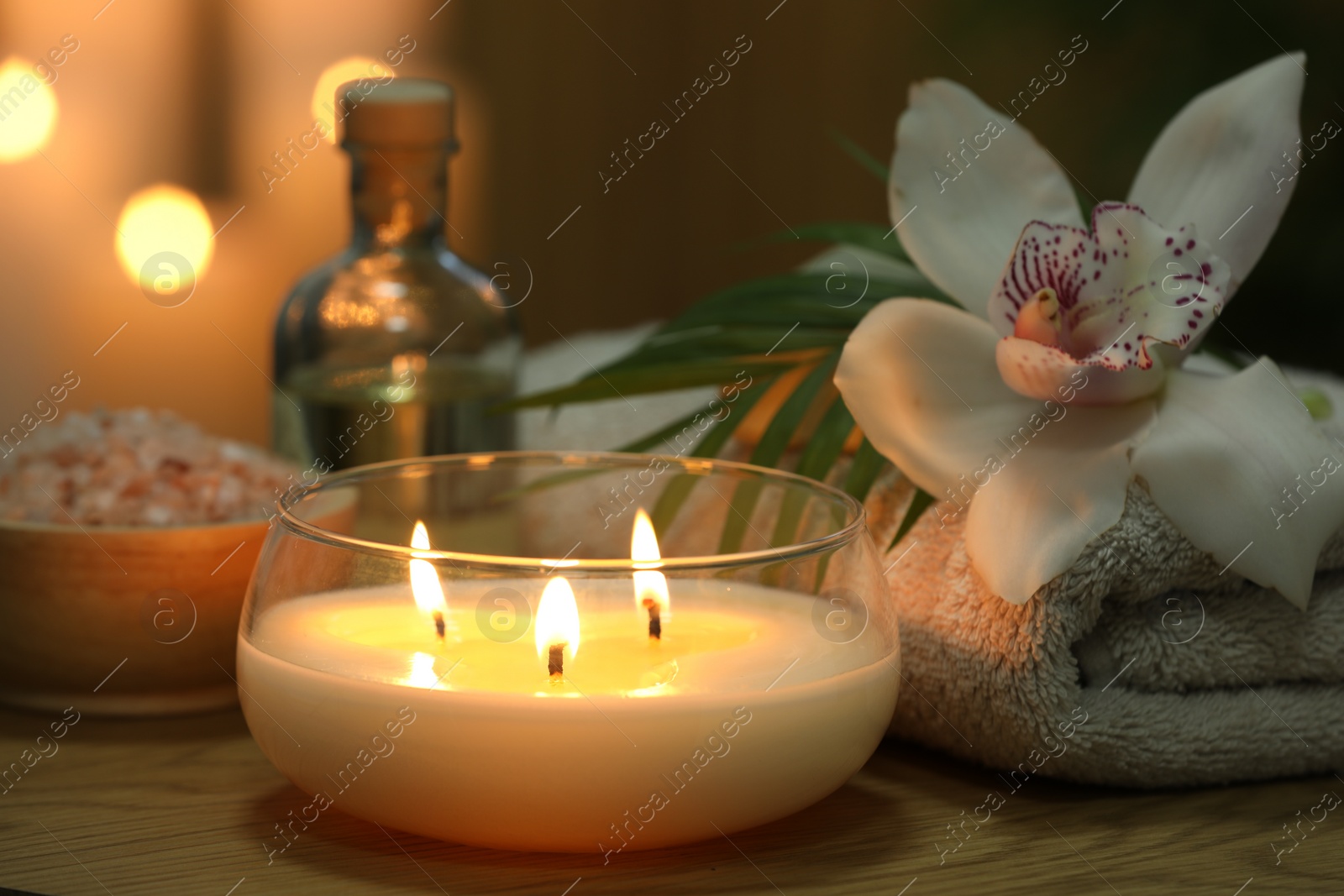 Photo of Beautiful spa composition with burning candle on wooden table, closeup