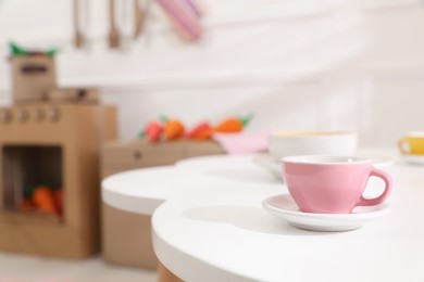 Cup on white table in kitchen, space for text