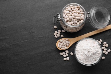 Photo of Bean flour and seeds on black table, flat lay. Space for text