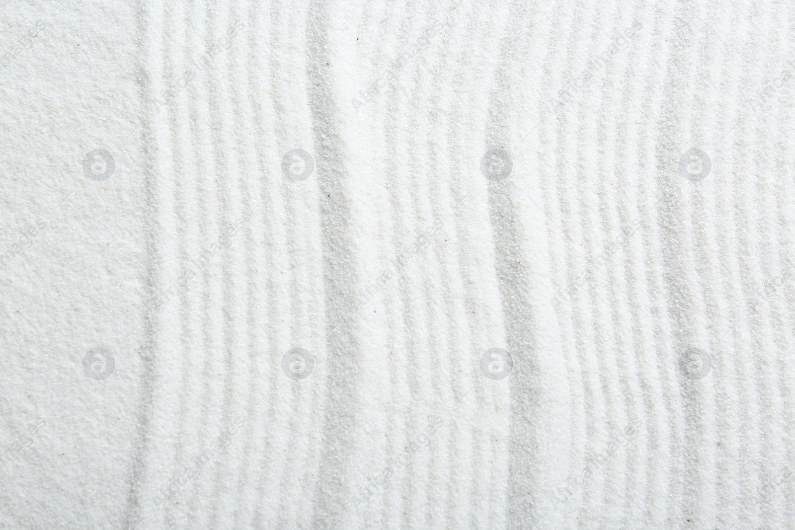 Photo of Zen rock garden. Wave pattern on white sand, top view