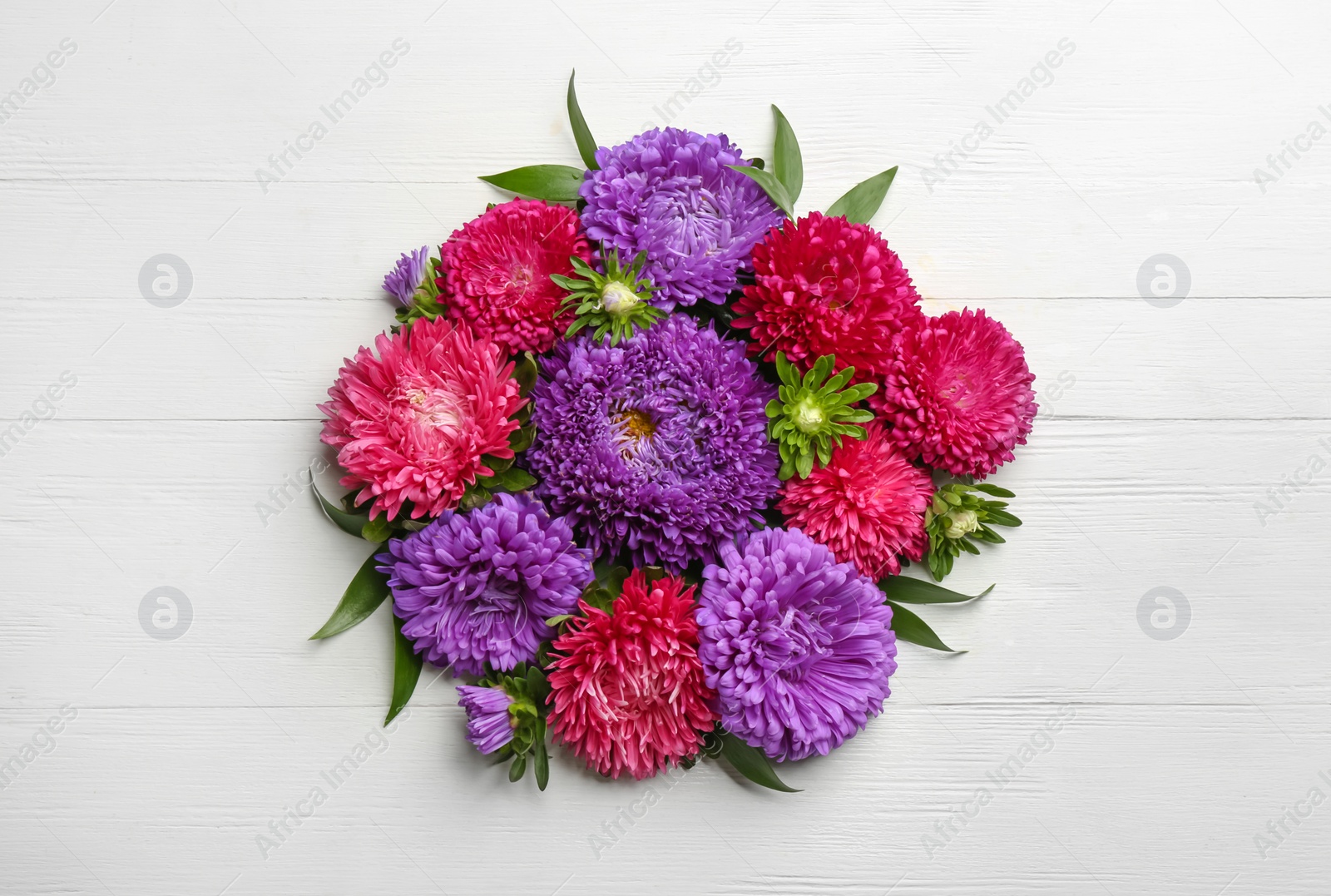 Photo of Beautiful asters on white wooden background, flat lay. Autumn flowers