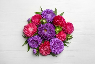 Beautiful asters on white wooden background, flat lay. Autumn flowers