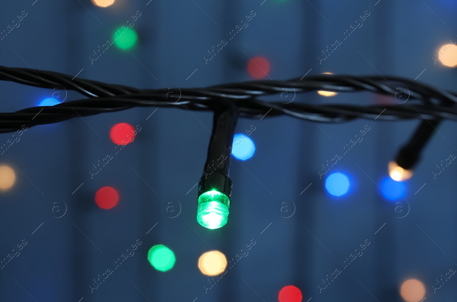 Photo of Beautiful Christmas lights on color background, closeup