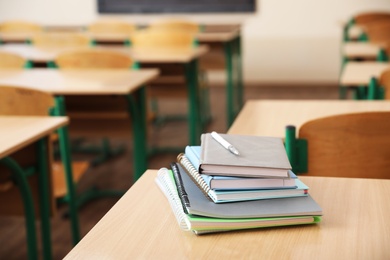 Stack of books on desk in classroom