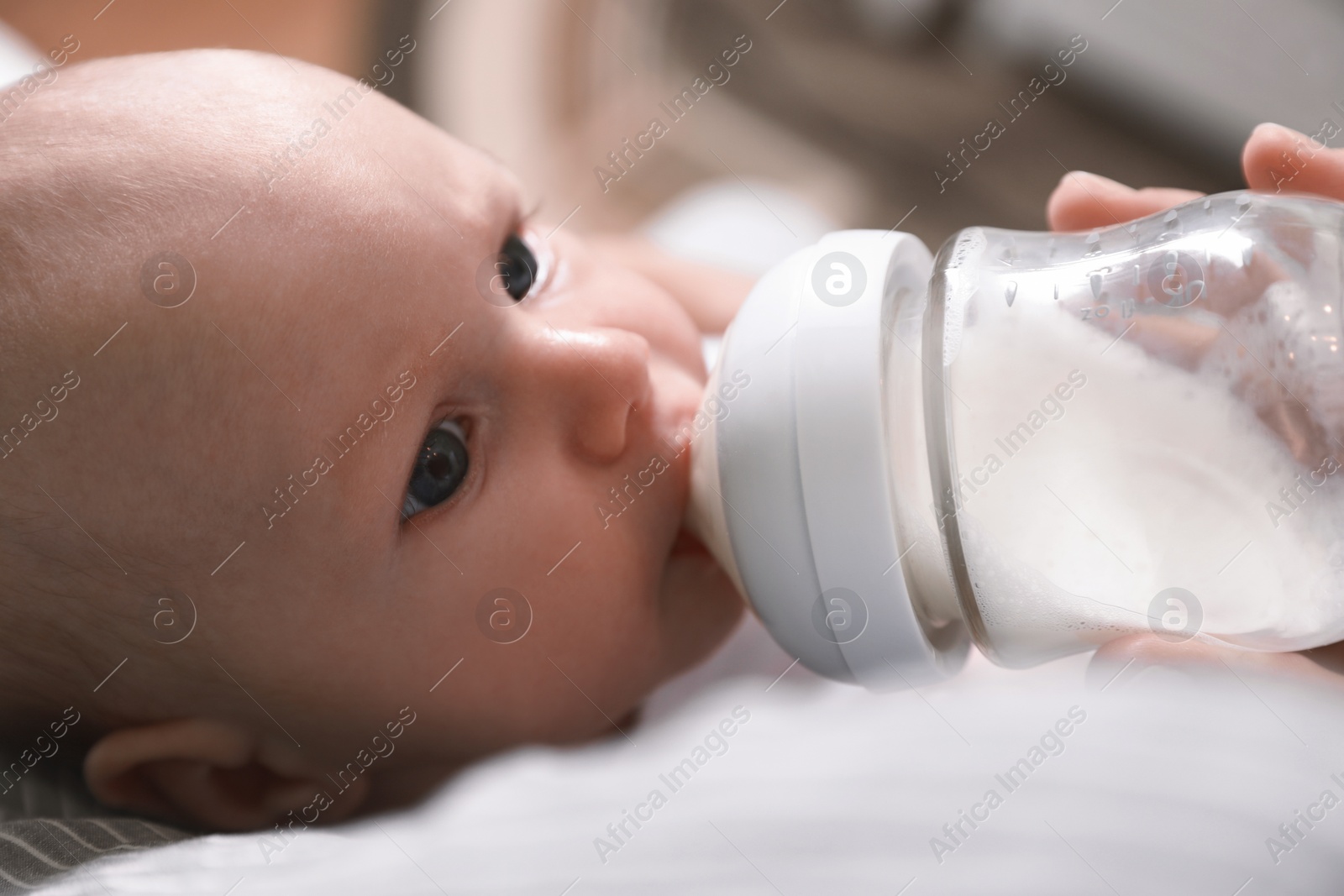 Photo of Mother feeding her little baby from bottle, closeup