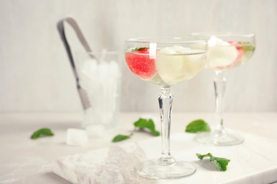 Glasses with tasty melon and watermelon ball drinks on light table