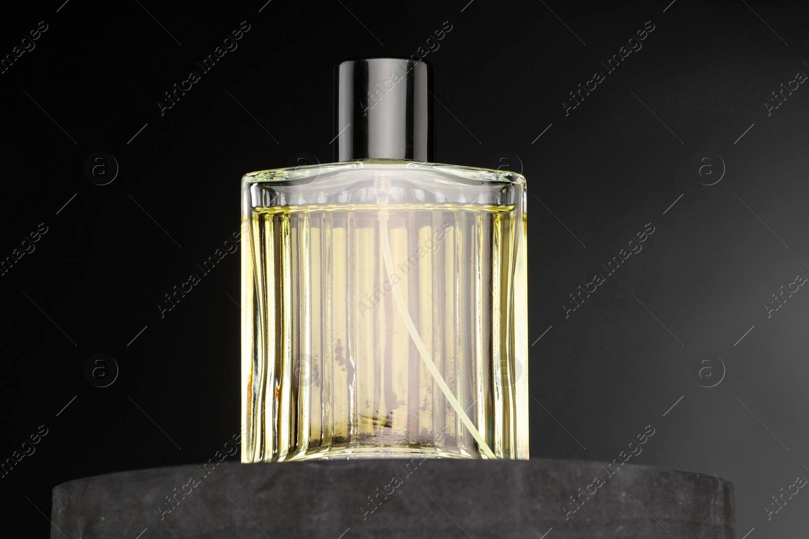 Photo of Luxury men`s perfume in bottle against dark background