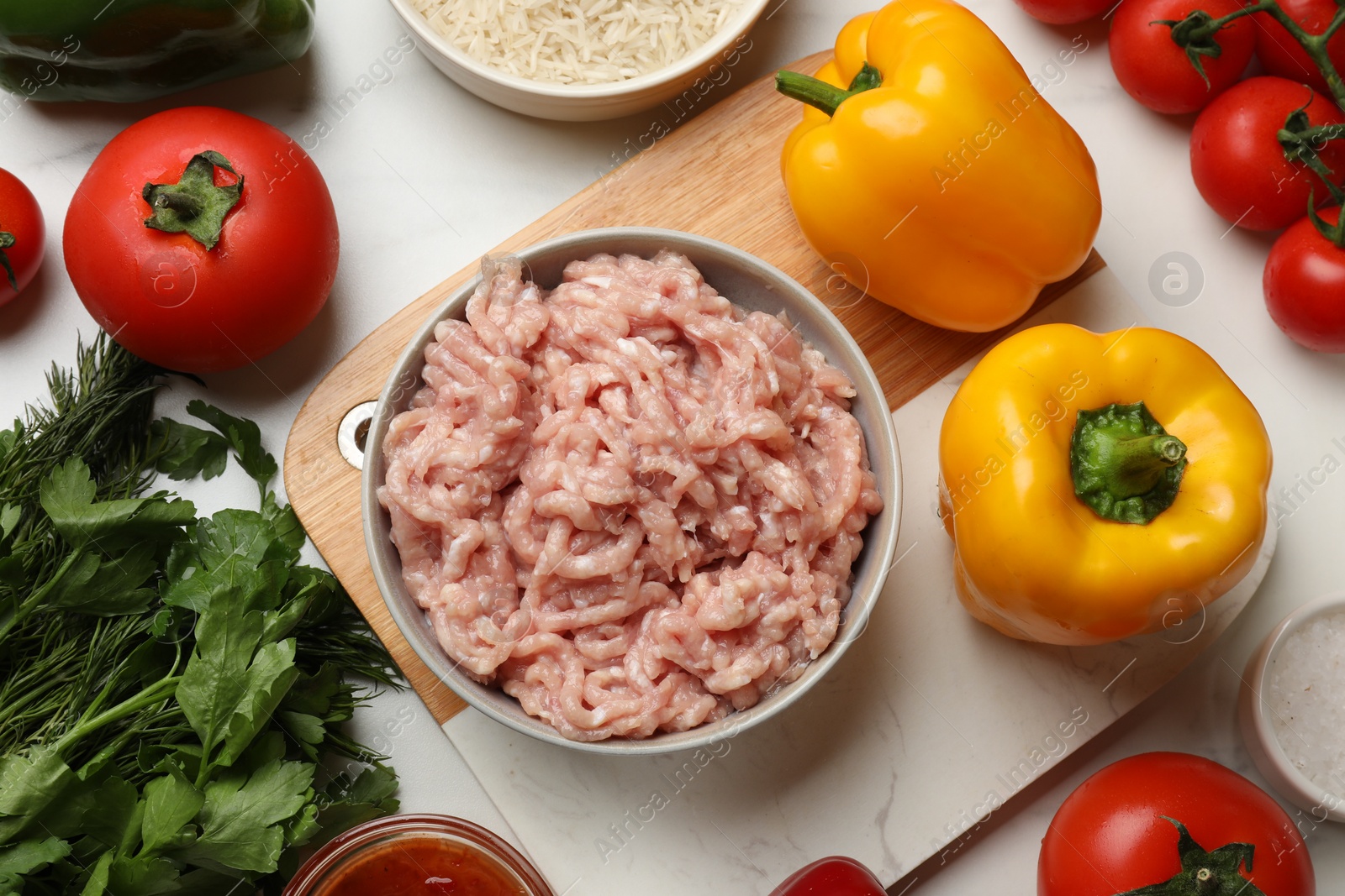 Photo of Making stuffed peppers. Ground meat and other ingredients on white marble table, flat lay