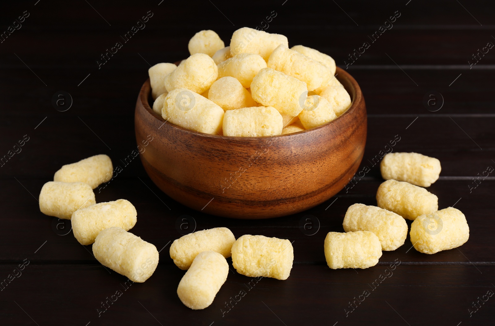 Photo of Bowl with corn sticks on dark wooden table