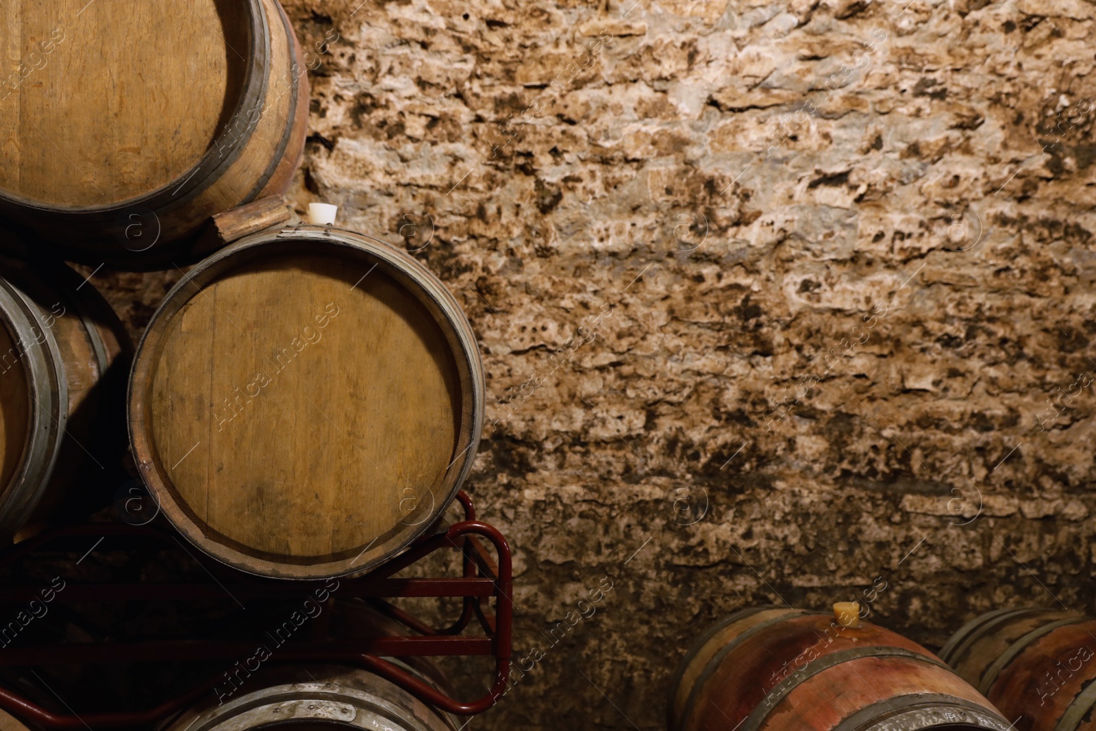 Photo of Wooden wine barrels near stone wall with space for text