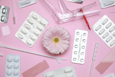 Photo of Many gynecological tools, pills and gerbera flower on pink background, flat lay