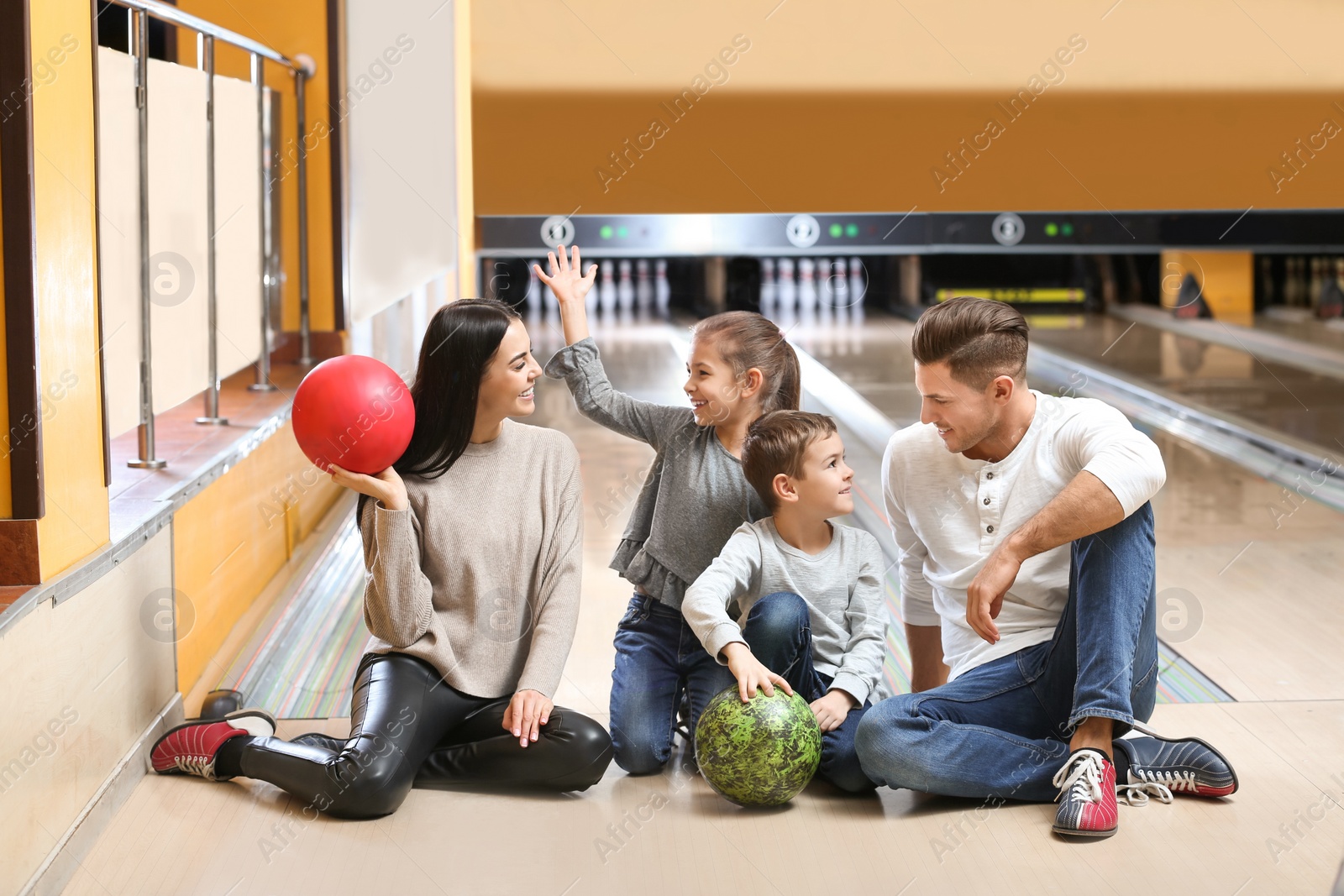 Photo of Happy family spending time together in bowling club