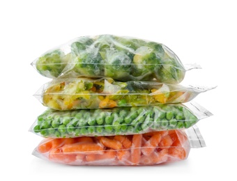 Photo of Plastic bags with frozen vegetables on white background