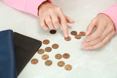 Photo of Woman counting coins at light table, closeup