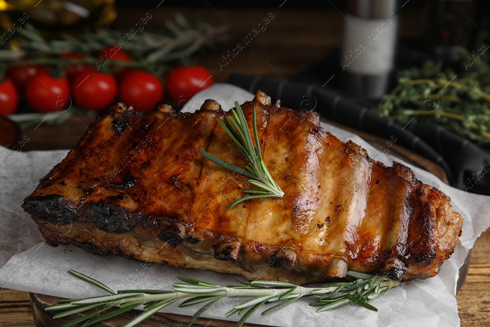 Photo of Tasty grilled ribs with rosemary on wooden table