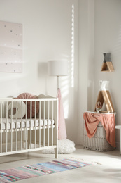 Photo of Cute baby room interior with crib and decor elements