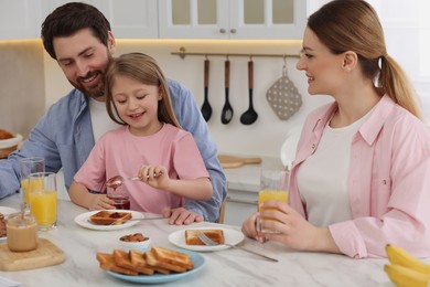 Happy family having breakfast at table in kitchen