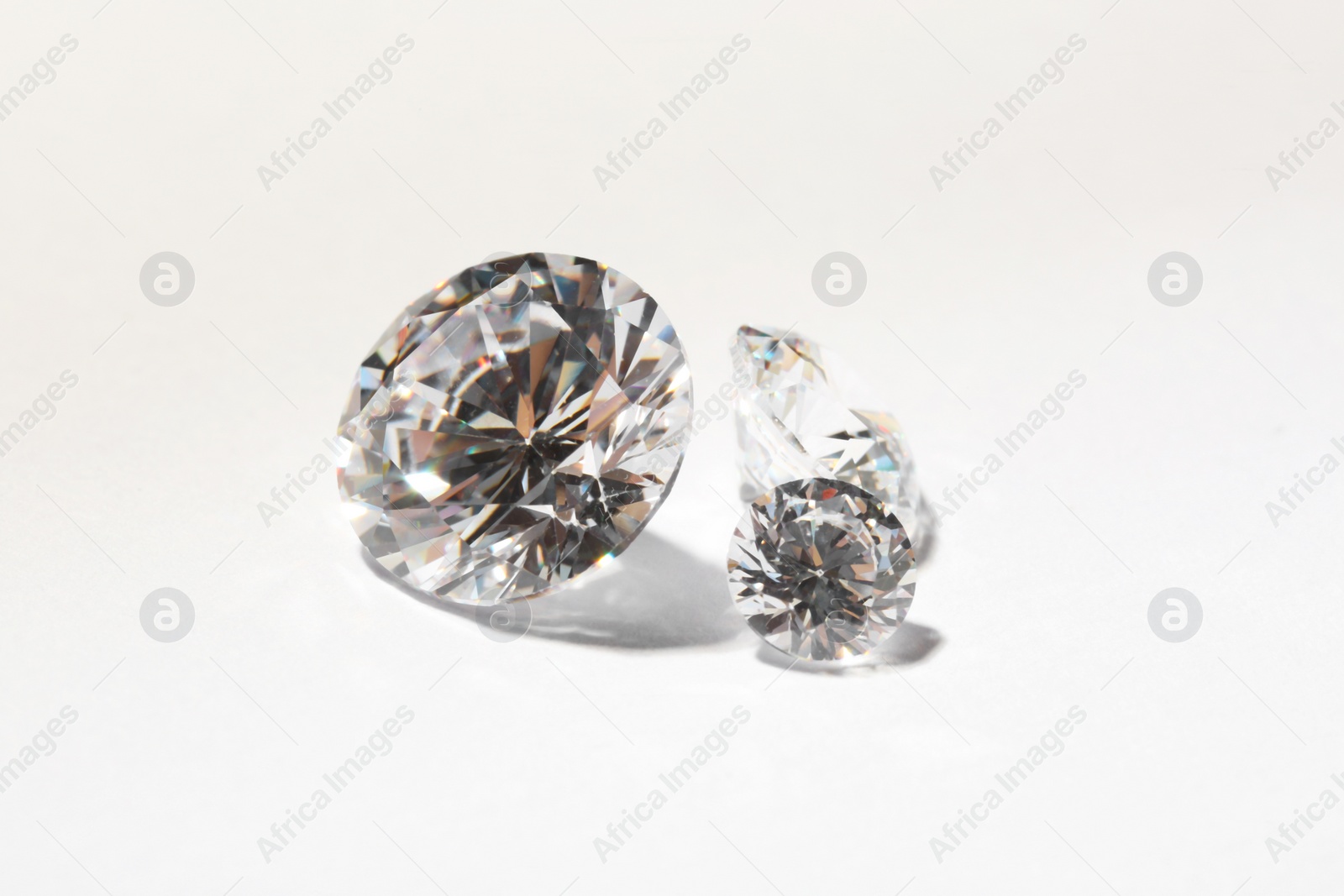 Photo of Different beautiful shiny diamonds on white background