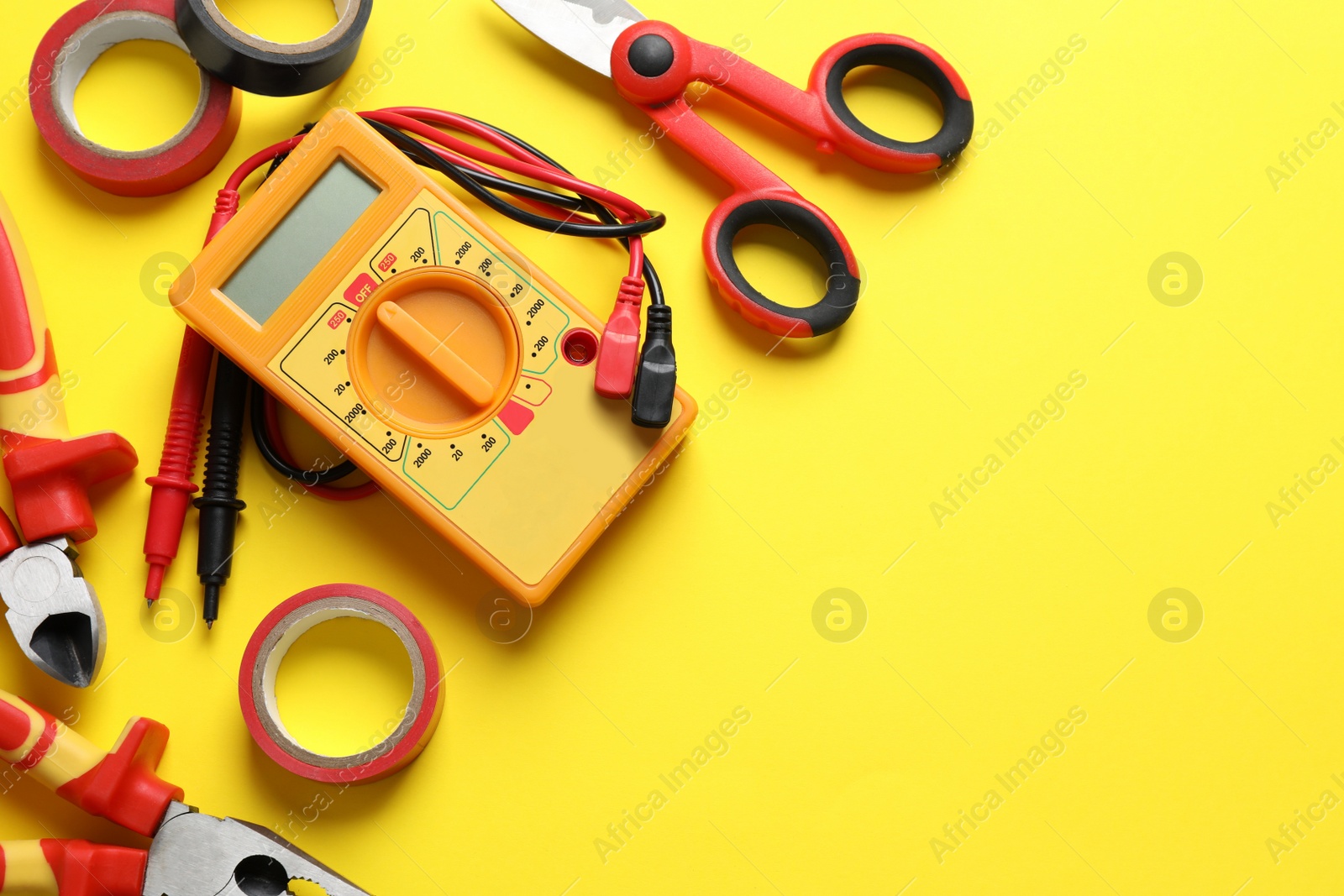 Photo of Flat lay composition with electrician's tools and accessories on yellow background, space for text