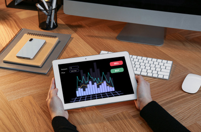 Image of Broker using tablet at workplace, closeup. Forex trading