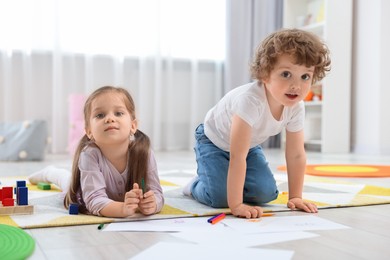 Cute little children drawing on floor in kindergarten