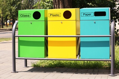 Photo of Waste sorting bins on city street. Recycling concept