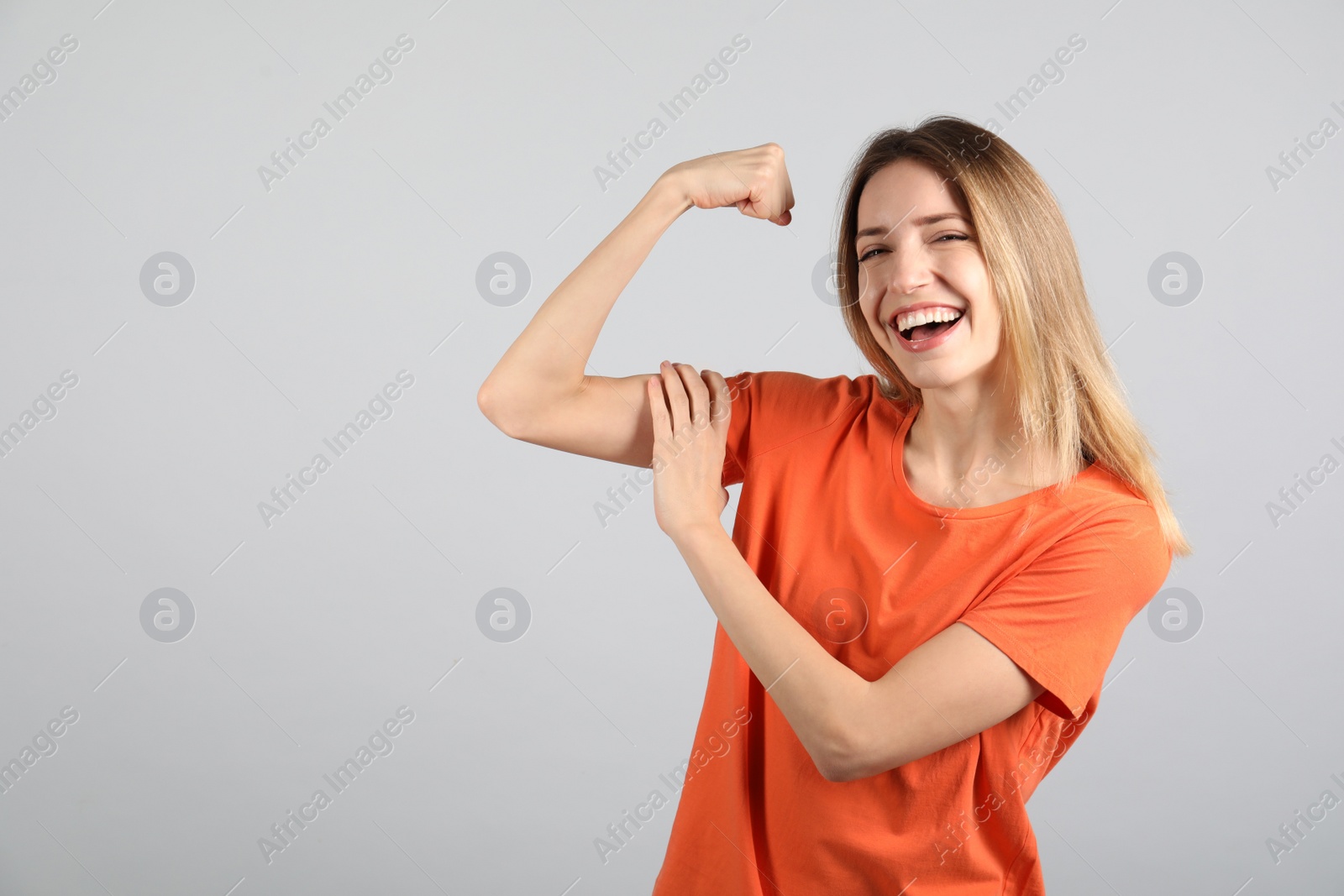 Photo of Strong woman as symbol of girl power on light grey background, space for text. 8 March concept