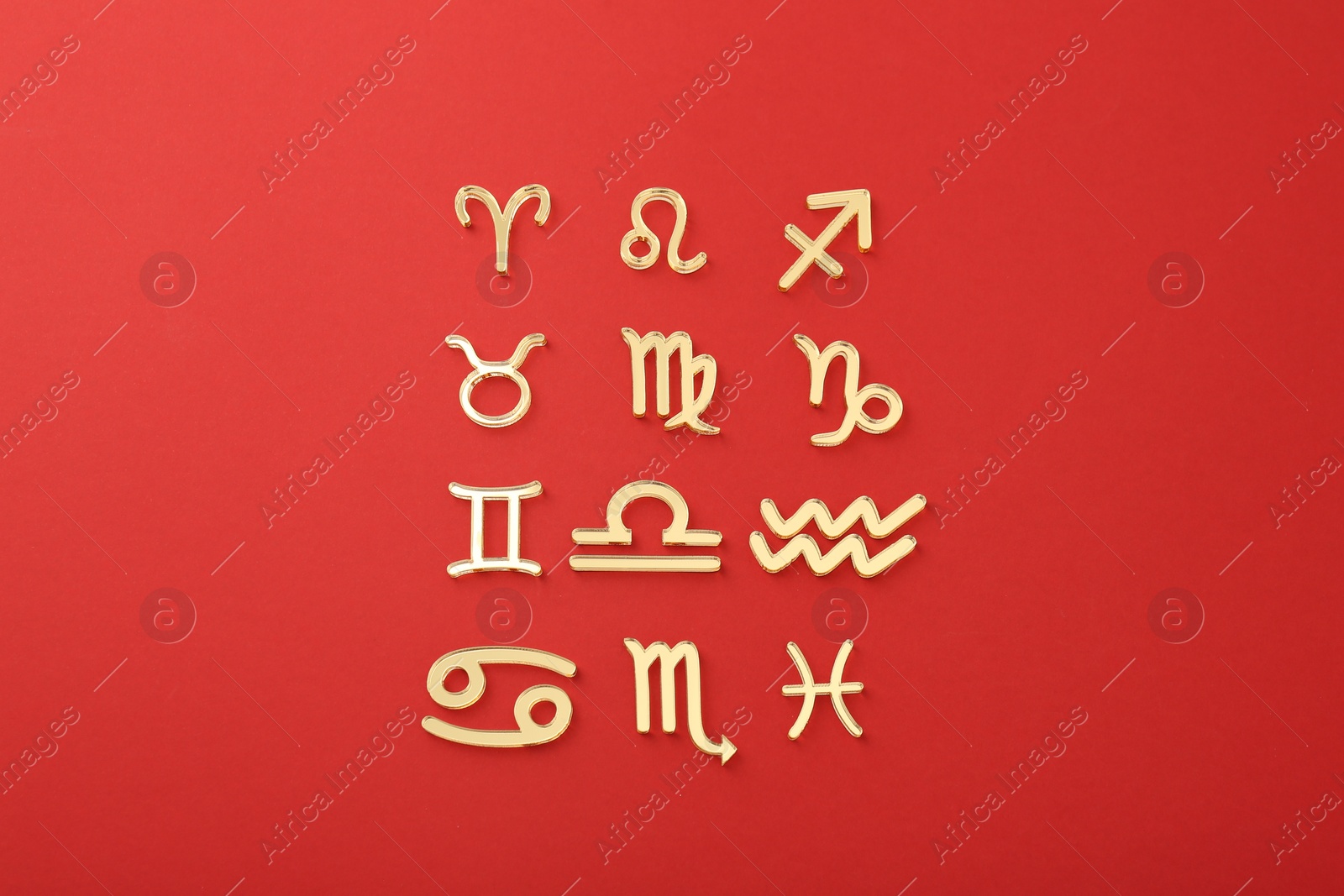 Photo of Zodiac signs on red background, flat lay