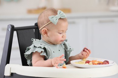 Photo of Cute little girl eating healthy food at home