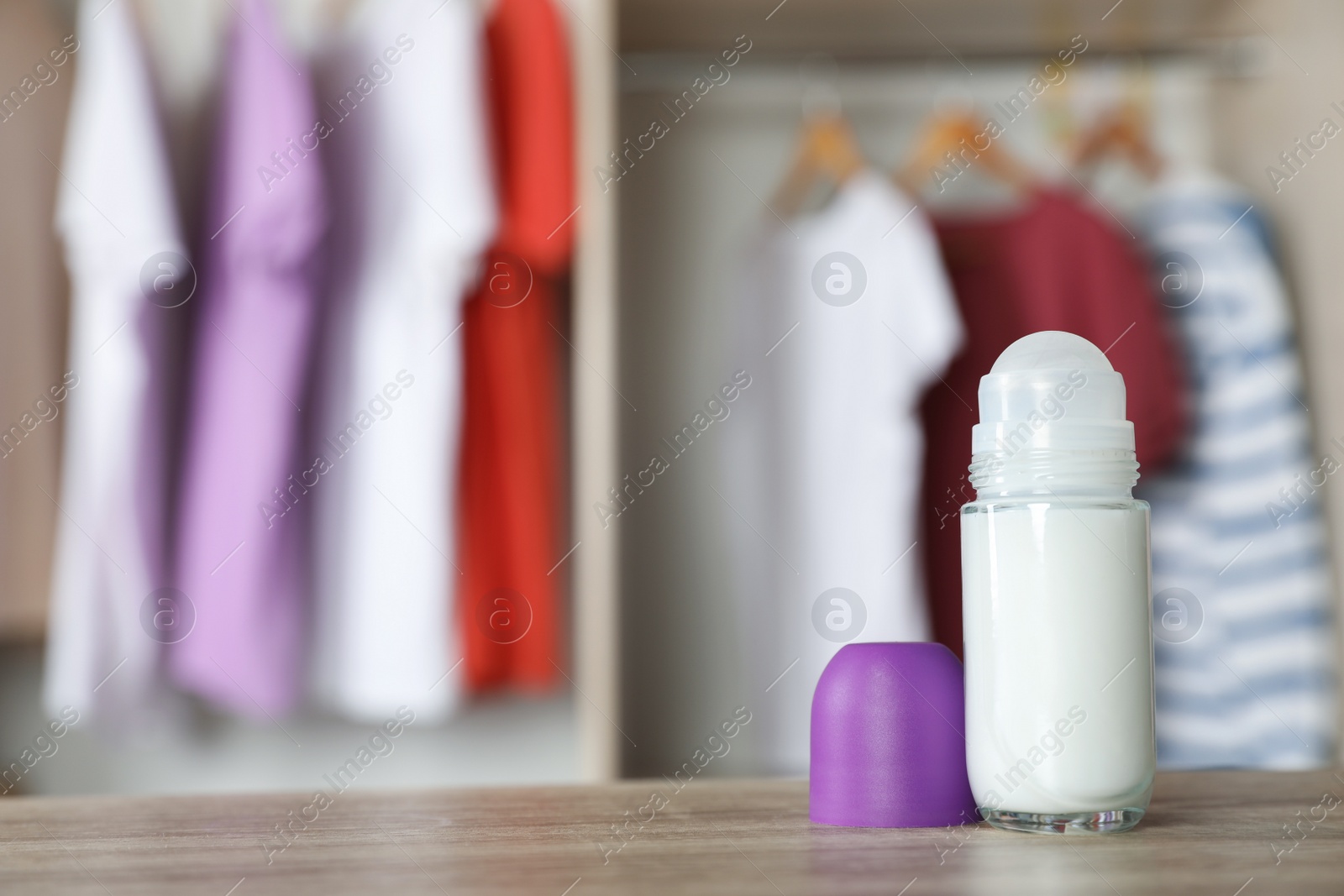 Photo of Deodorant on wooden table indoors. Space for text