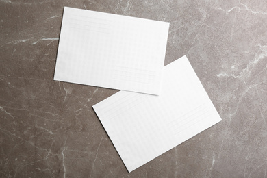 Photo of White paper envelopes on marble background, flat lay