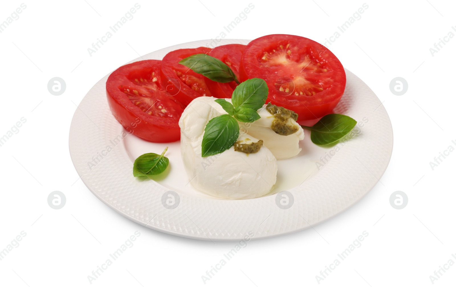 Photo of Plate of tasty Caprese salad with mozzarella, tomatoes, basil and pesto sauce isolated on white