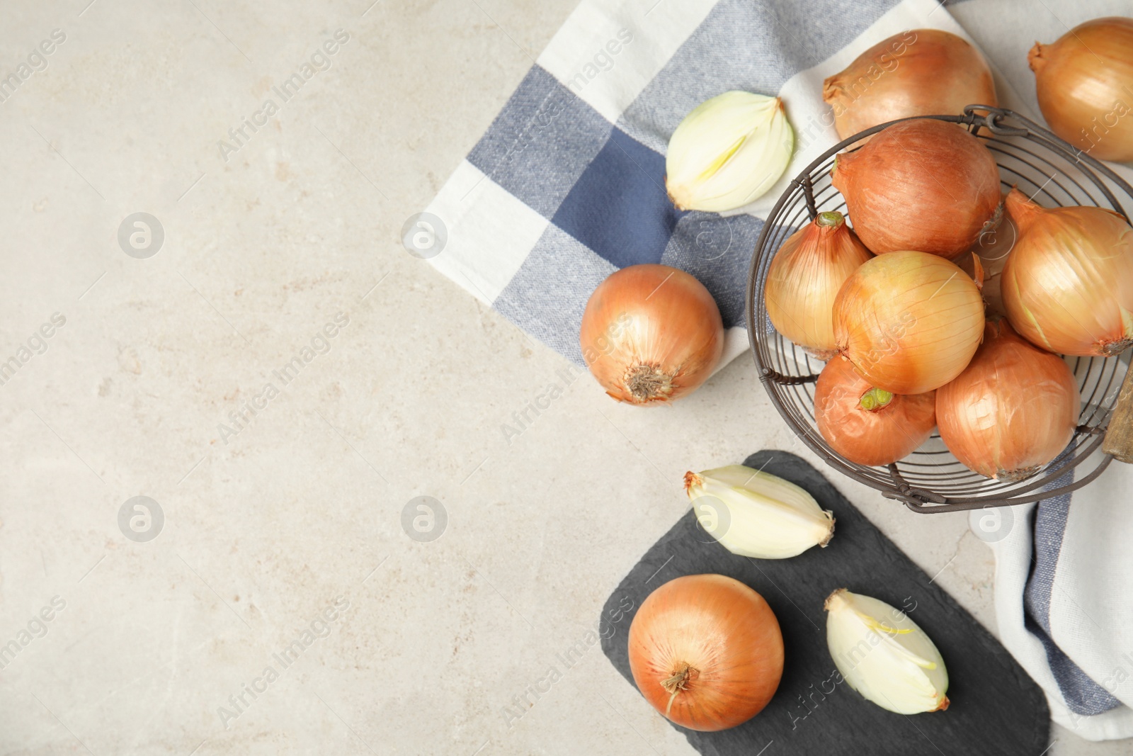 Photo of Flat lay composition with ripe onions on grey table, space for text