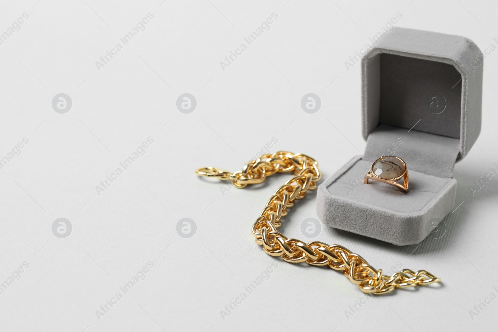 Photo of Jewelry box with ring and bracelet on light background, space for text