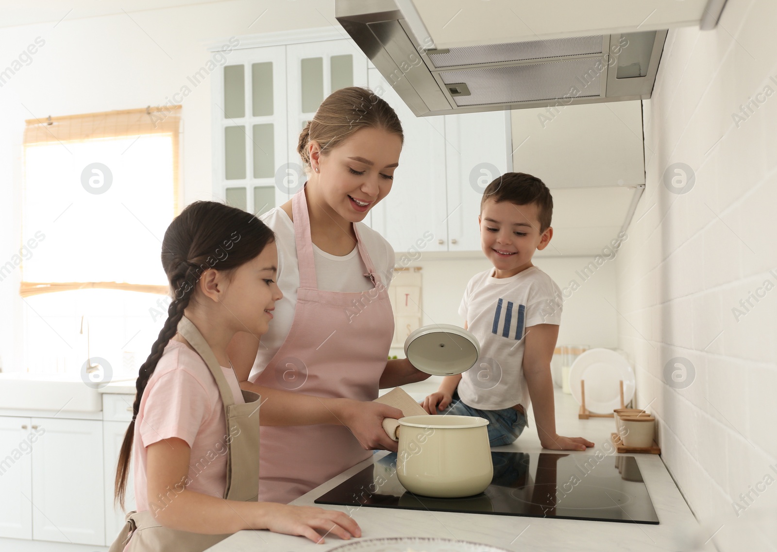 Photo of Happy family cooking together in kitchen at home