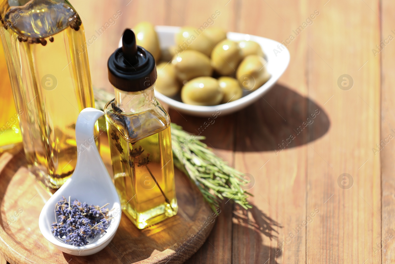 Photo of Different cooking oils and ingredients on wooden table, closeup. Space for text