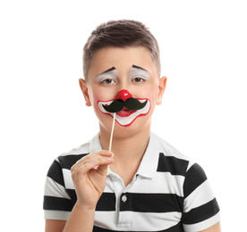 Photo of Preteen boy with clown makeup and fake mustache on white background. April fool's day