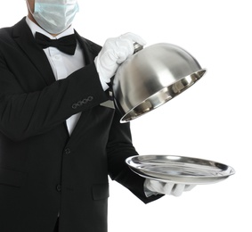 Waiter in medical mask holding tray with lid on white background, closeup