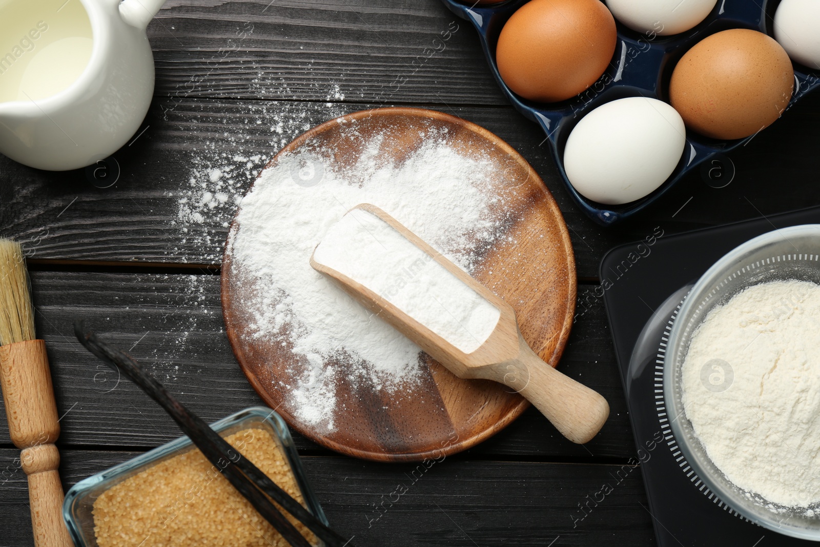 Photo of Flat lay composition with baking powder and products on black wooden table