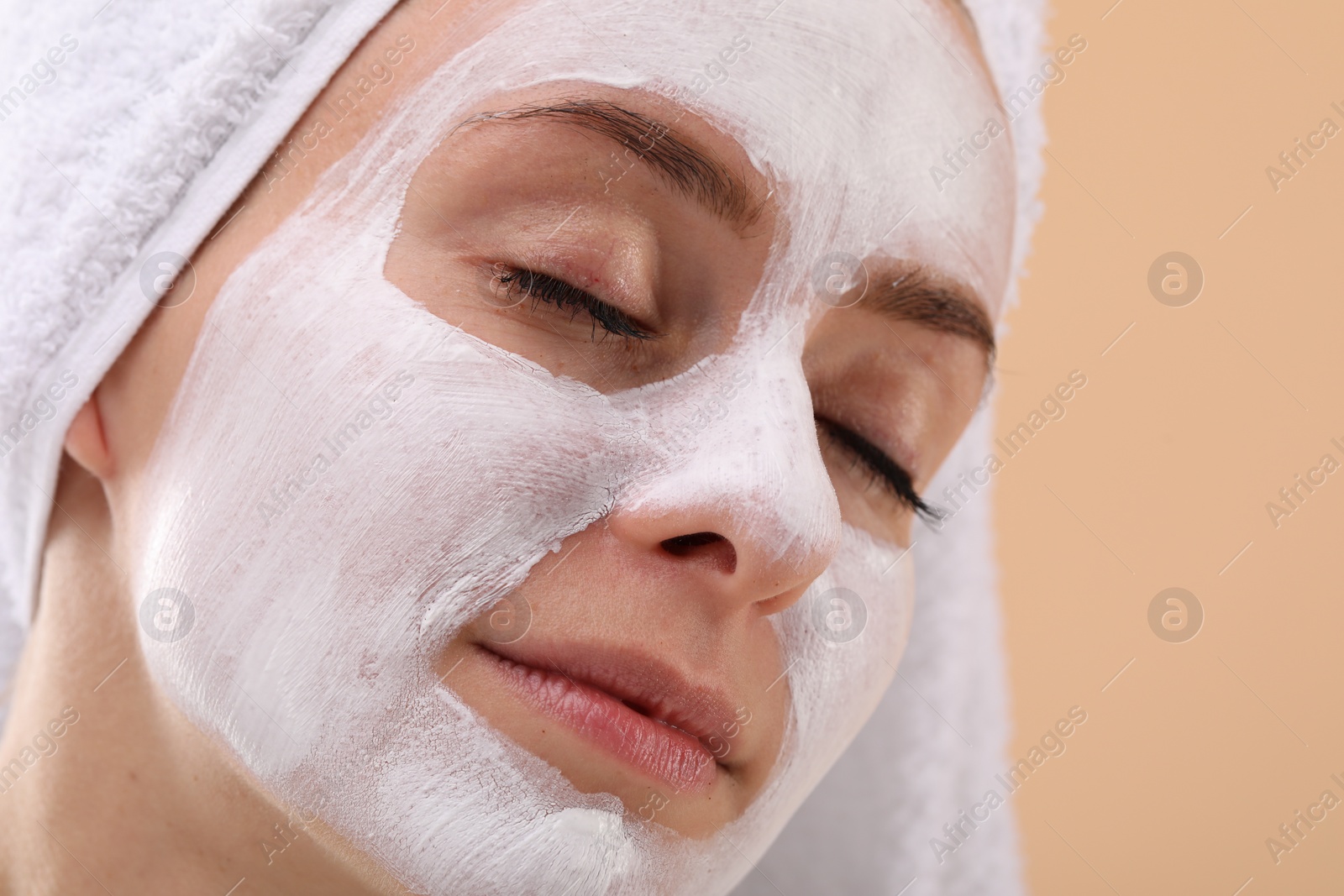 Photo of Woman with face mask on beige background, closeup and space for text. Spa treatments