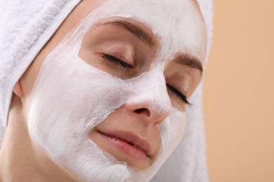 Woman with face mask on beige background, closeup and space for text. Spa treatments